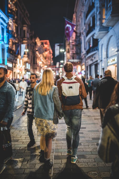 Unrecognizable couple walking along city street