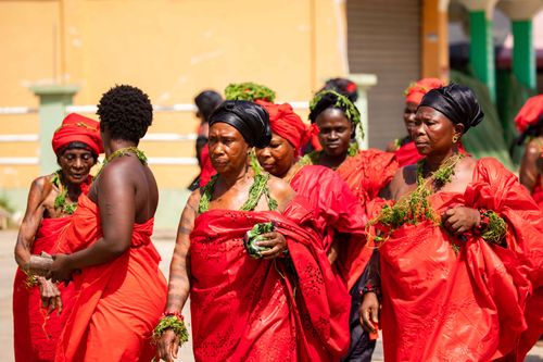Free A group of women in vibrant red traditional attire participate in a cultural ceremony outdoors. Stock Photo