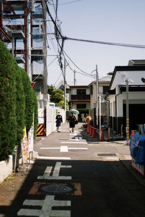 Free A peaceful scene in a Japanese urban neighborhood with people walking. Stock Photo