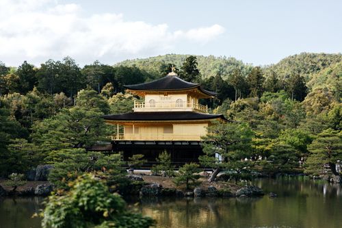 Free Beautiful view of the Golden Pavilion, Kinkaku-ji Temple, reflected in a serene pond in Kyoto's lush green setting. Stock Photo
