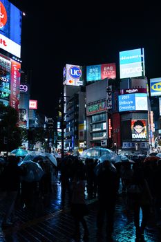 Vibrant nightscape of Shibuya Crossing in Tokyo with illuminated billboards and bustling crowd.
