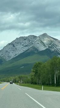 A picturesque road leading to majestic mountains in Banff National Park, Canada.