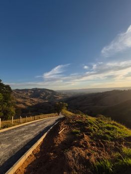 Capture the breathtaking landscape of Minas Gerais with rolling hills under a warm sunset.
