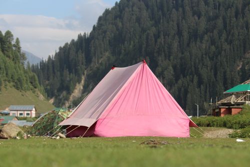 Free A bright pink tent set against a lush mountainous backdrop, showcasing outdoor adventure and camping. Stock Photo