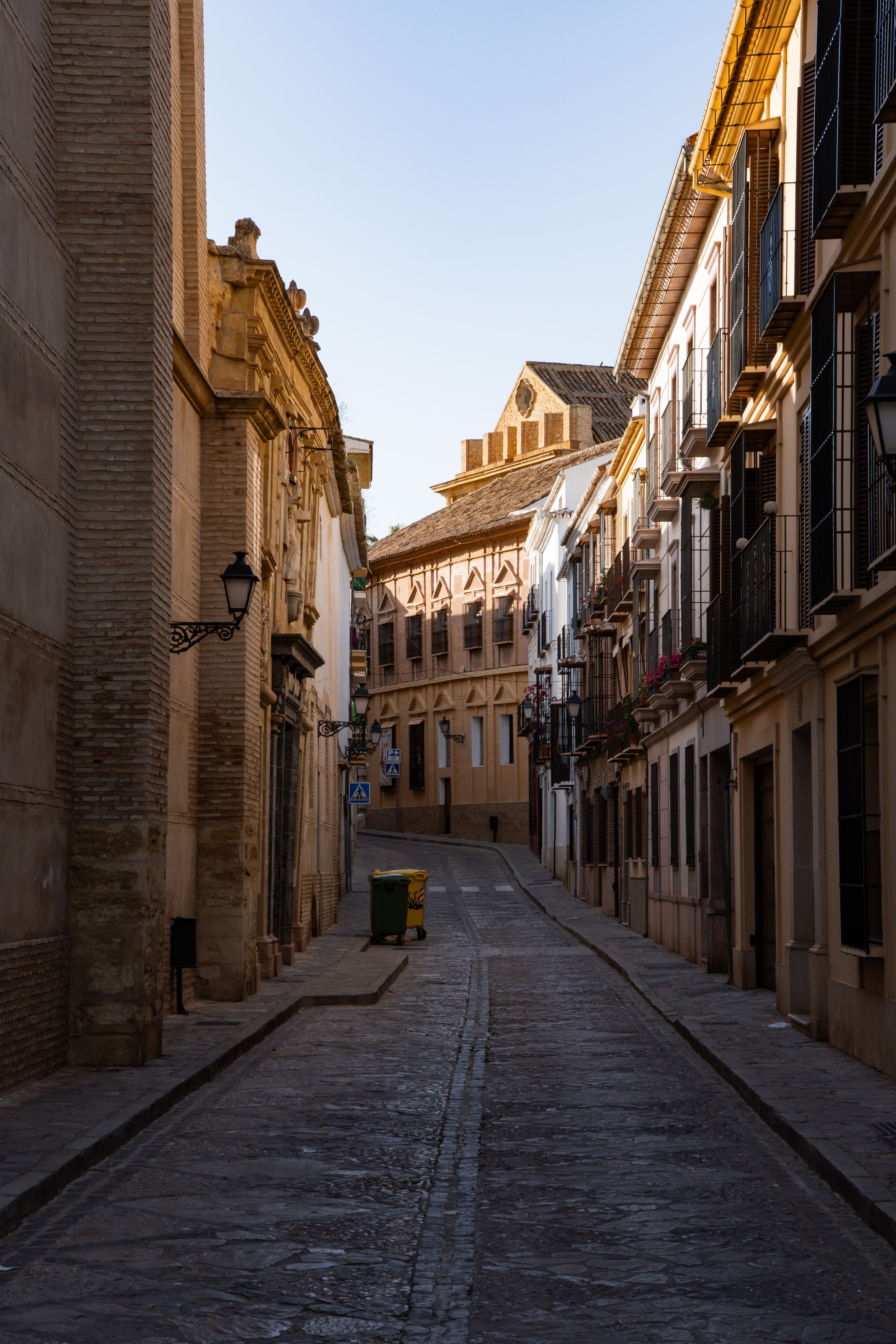 Narrow cobblestone street in Antequera, Spain, featuring historic Andalusian architecture.