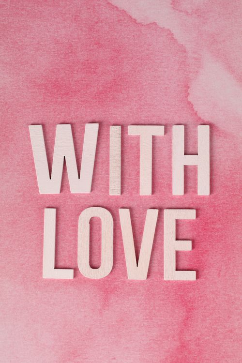 Free Pink watercolor background with 'WITH LOVE' text for romantic themes. Stock Photo
