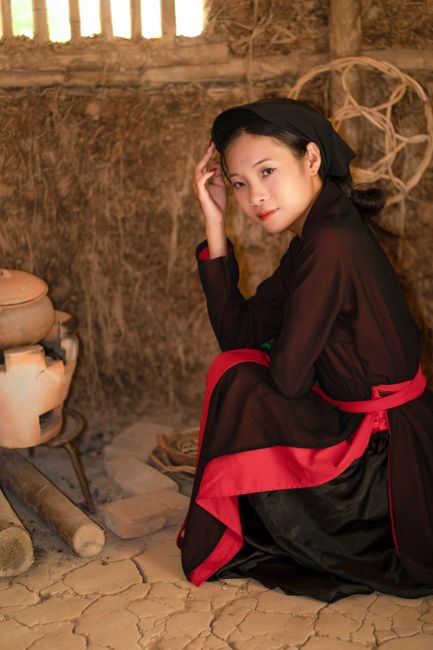 Young woman in traditional Vietnamese clothing seated indoors.