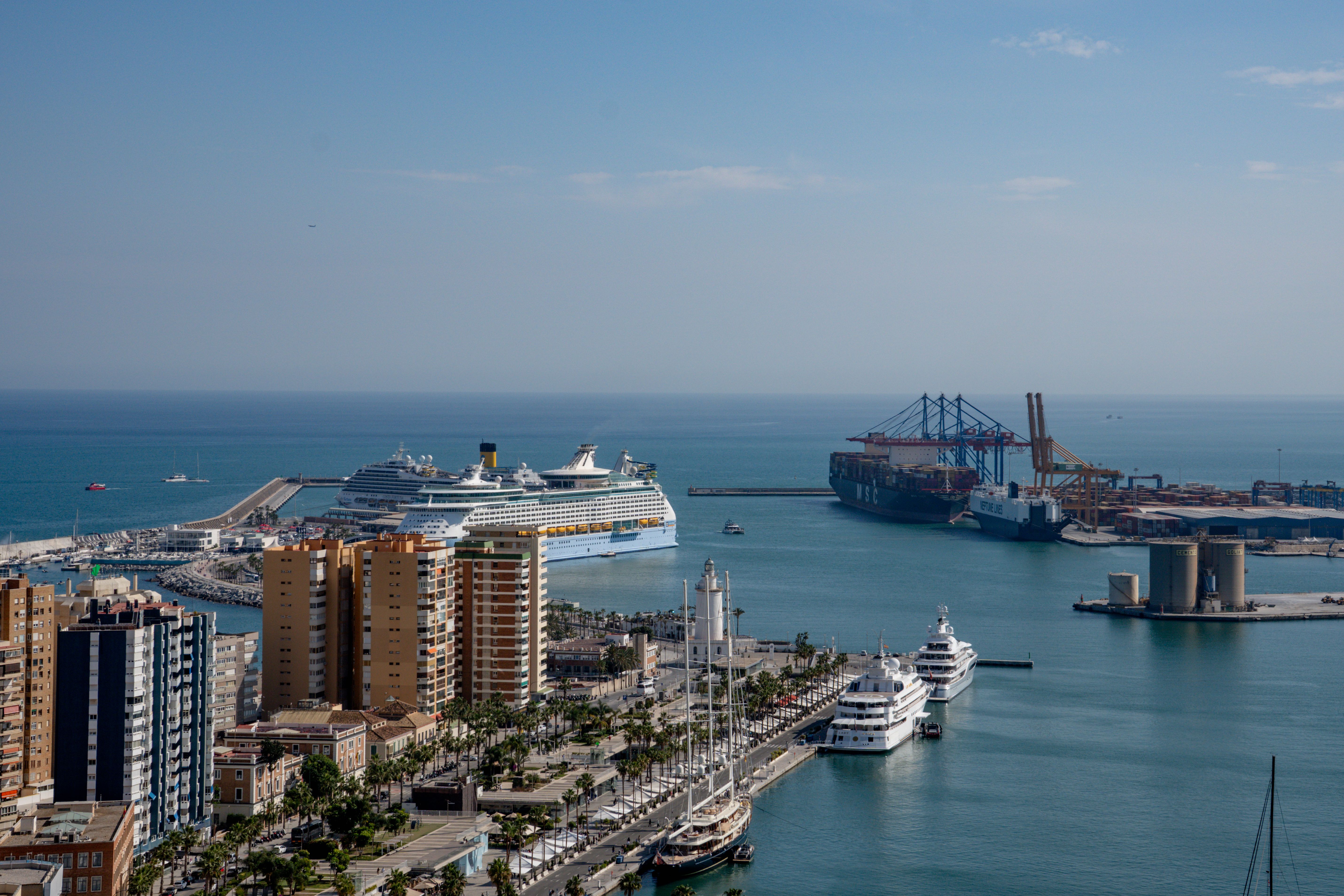 Breathtaking view of Málaga harbor showcasing cruise ships, palm-lined promenade, and the Mediterranean Sea.
