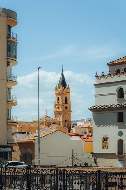 Captivating view of Malaga with a classic tower in the city center, under a sunny day.