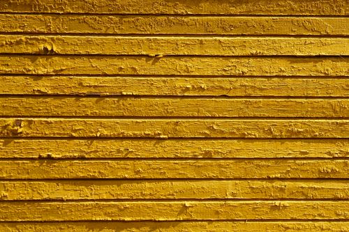 Free Close-up of a textured yellow wooden wall with peeling paint, showcasing a vintage aesthetic. Stock Photo
