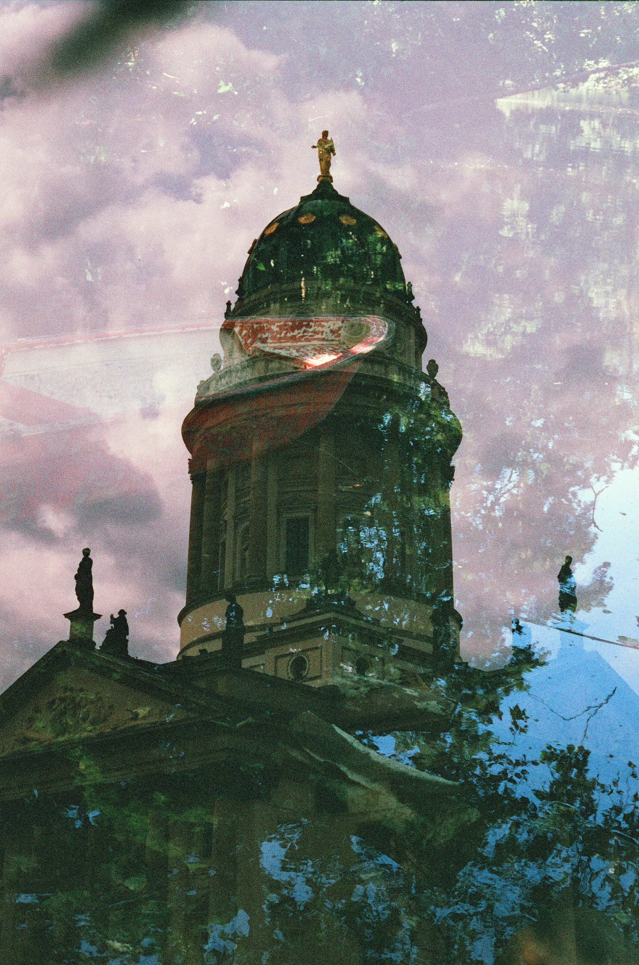 Artistic double exposure capturing Berlin Cathedral blended with nature.