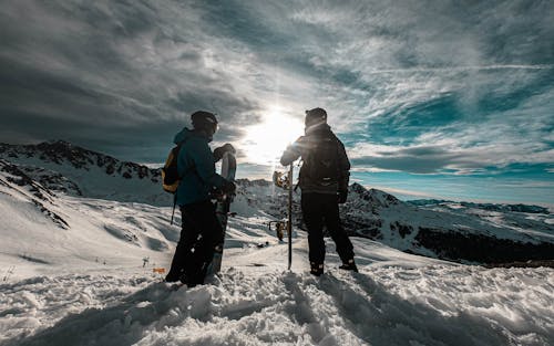 Two People with Snowboards Standing on the Ski Slope 