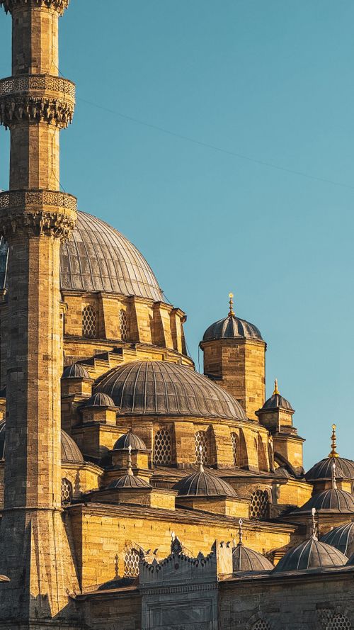 Free Stunning view of an Ottoman mosque's intricate architecture under a clear blue sky at sunset. Stock Photo