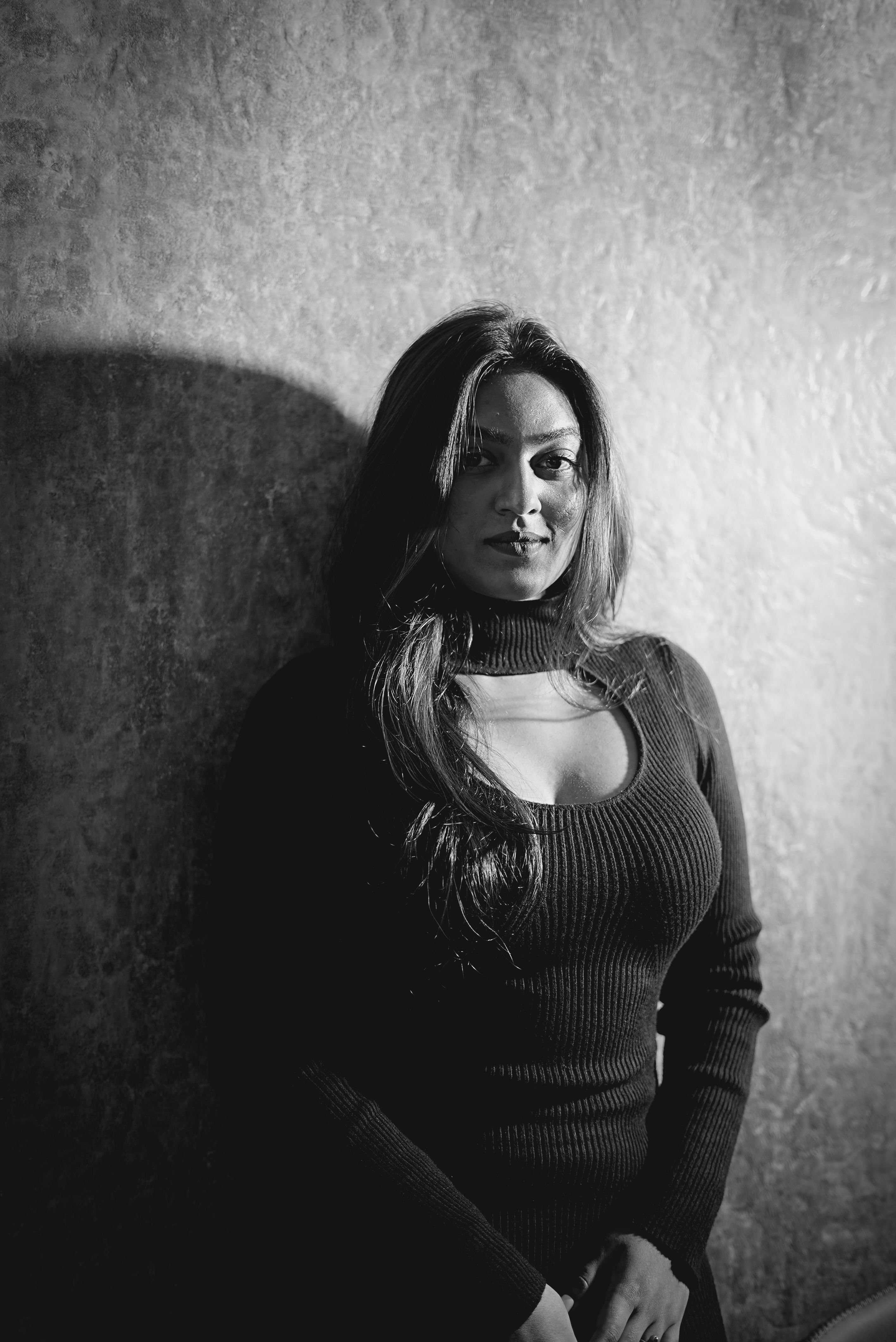 Dramatic black and white portrait of a woman in a dark setting.