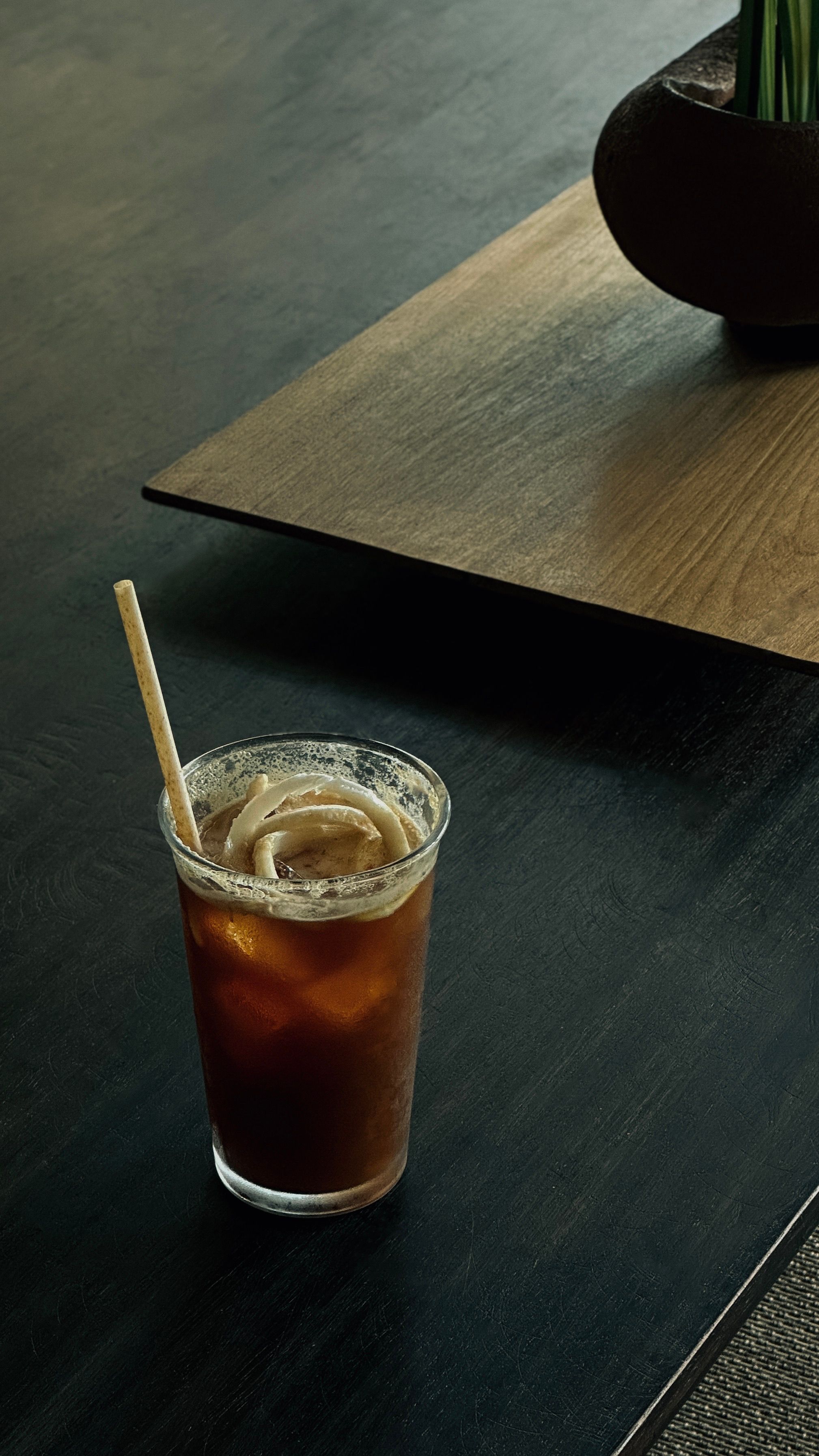 Gratis Un bicchiere di caffè freddo con una cannuccia sul tavolino di un moderno bar di Ho Chi Minh City. Foto a disposizione
