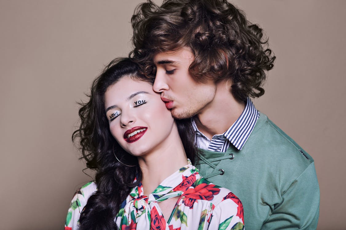 бесплатная Портрет молодой пары, поцелуи на сером фоне Стоковое фото