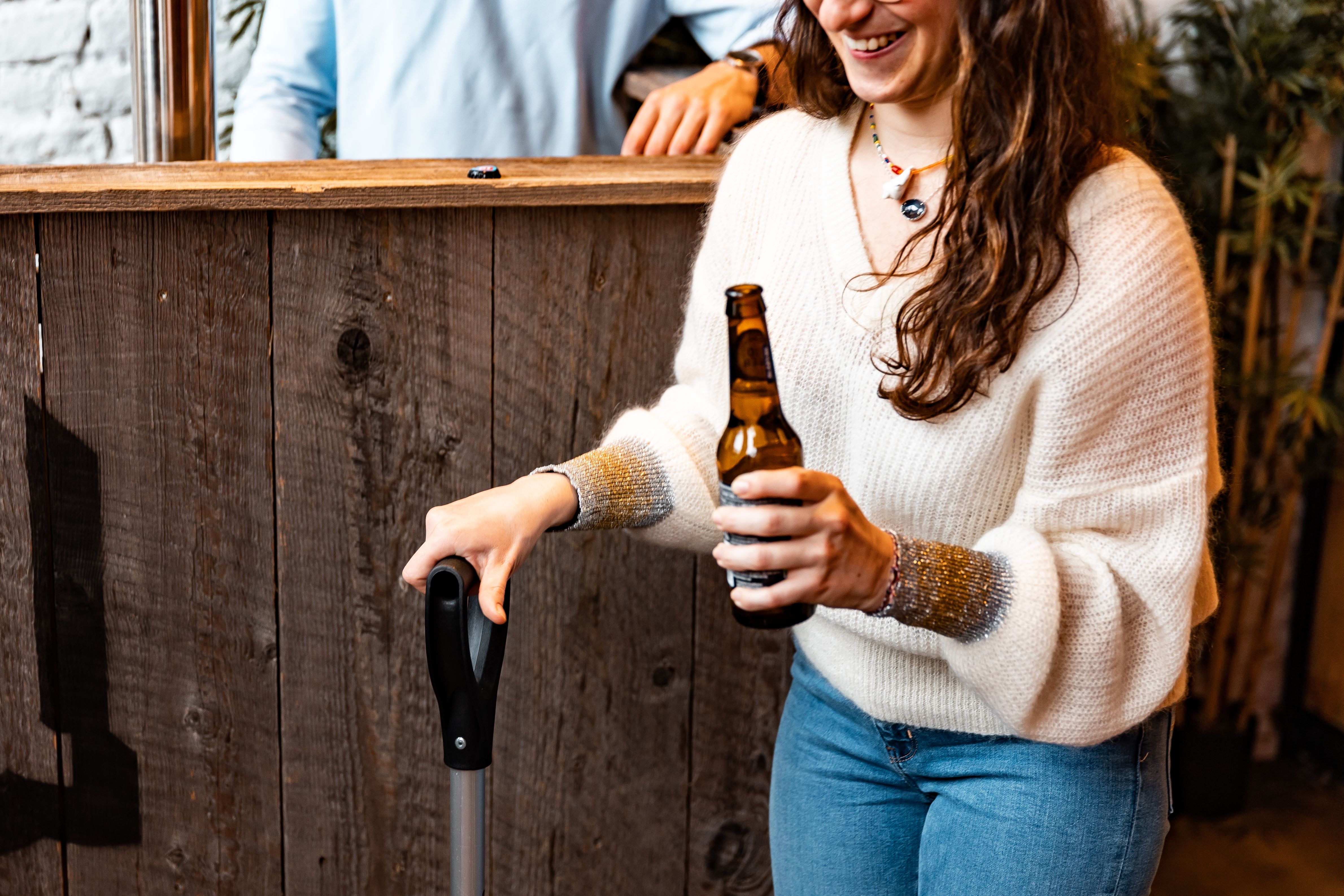 Woman enjoying a drink in a casual bar setting with a wooden counter.