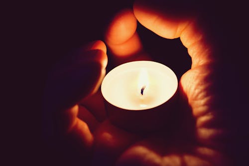 Person Holding White Tealight Candle