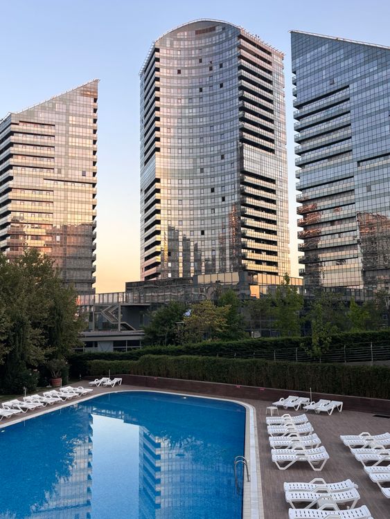 Modern High-Rise Buildings by a Pool at Dusk · Free Stock Photo