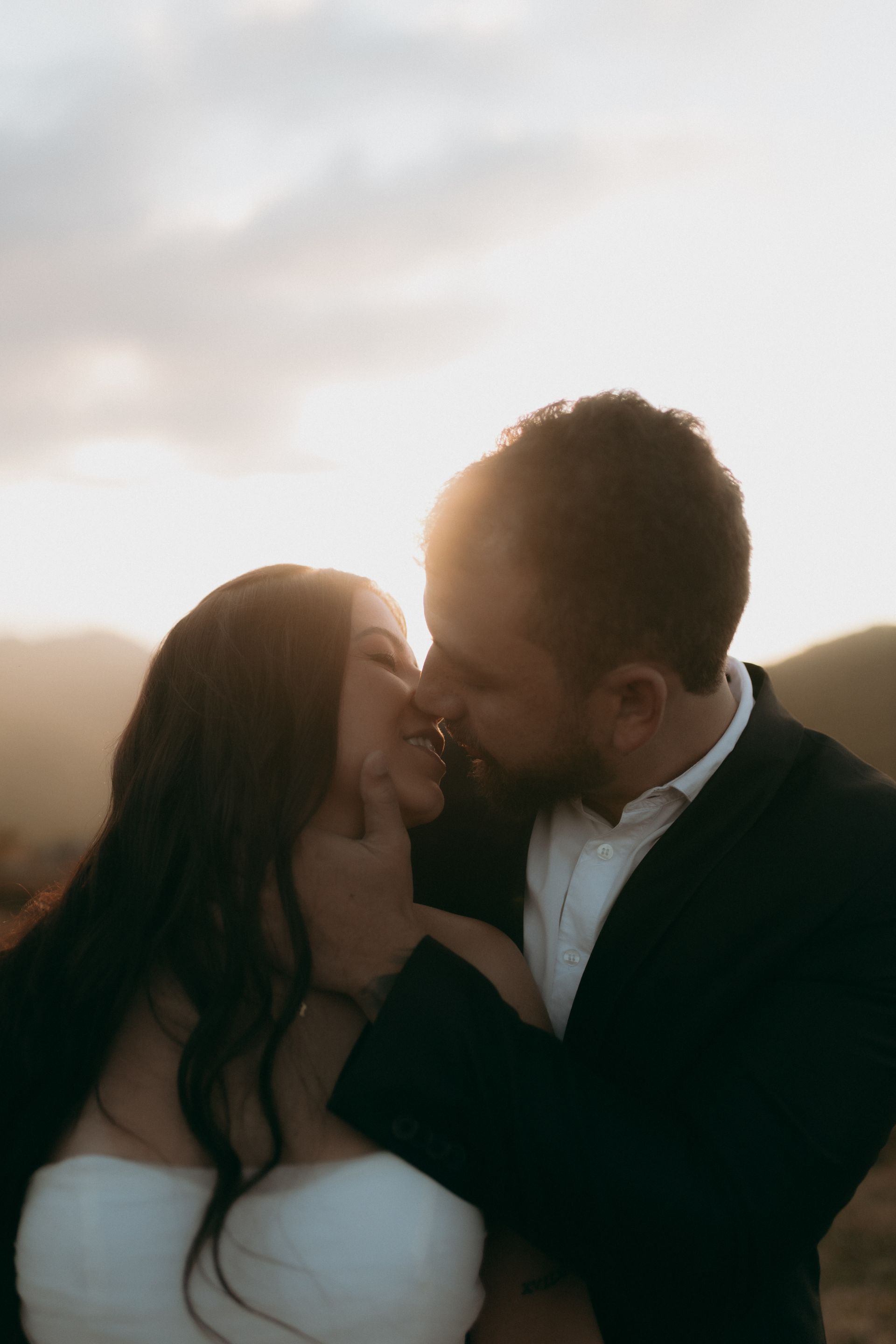A loving couple shares an intimate moment outdoors during a beautiful sunset, radiating pure joy and love