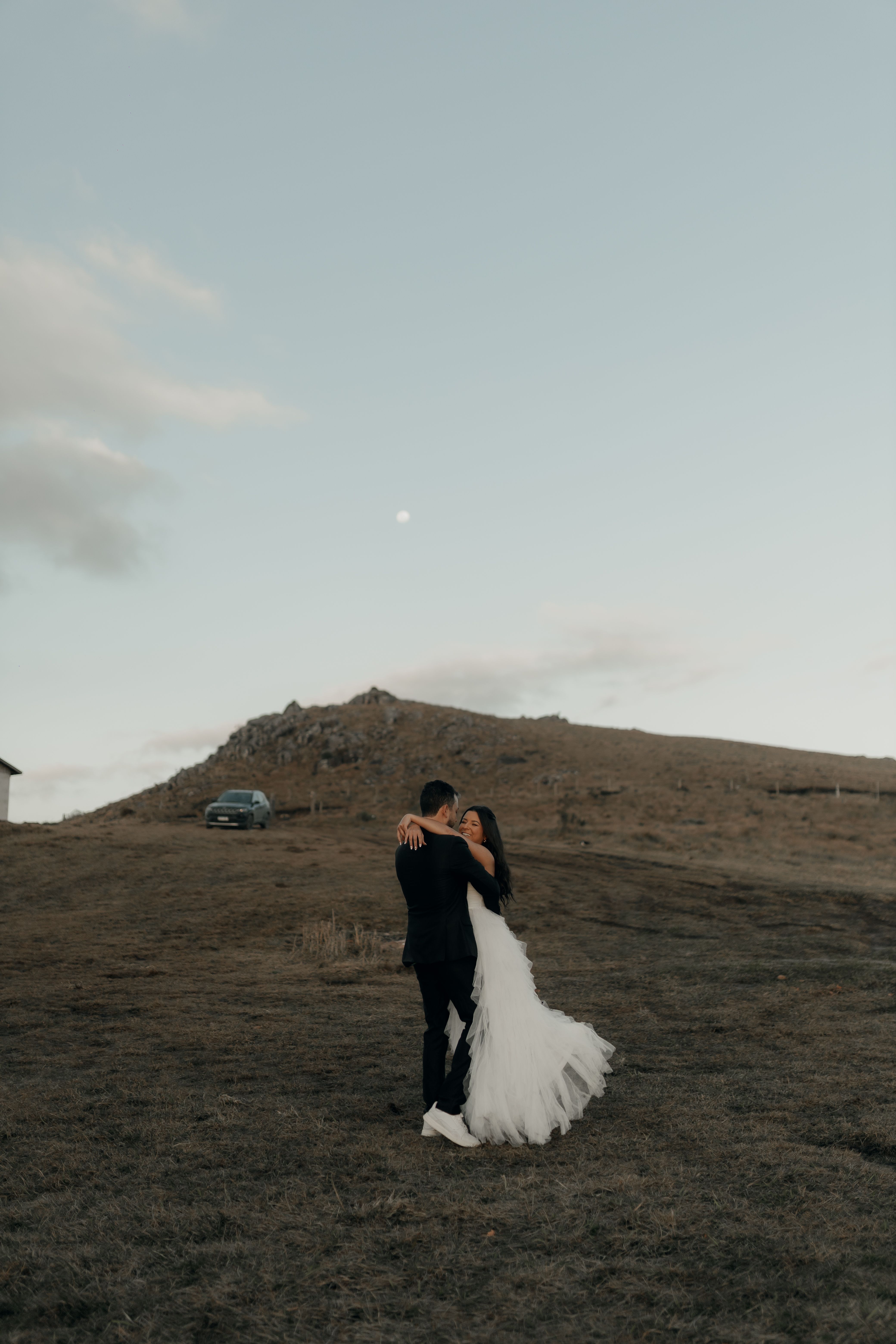 Romantic outdoor wedding couple embrace at dusk · Free Stock Photo