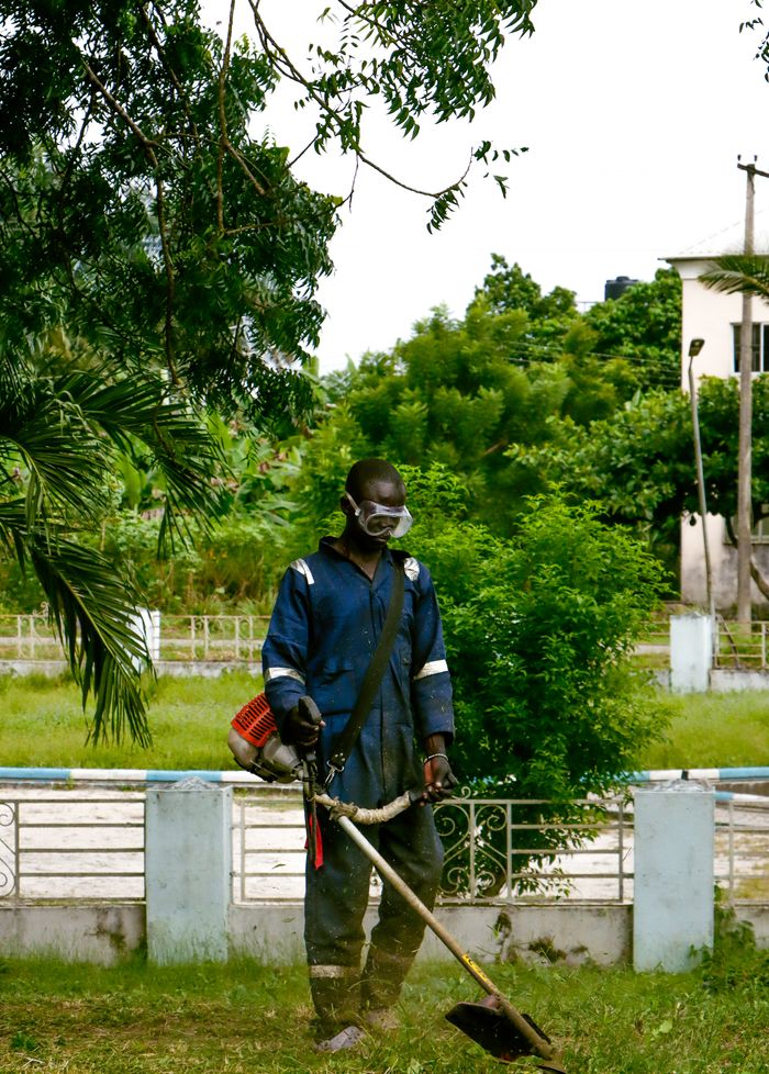 South African gardener operating a brush cutter