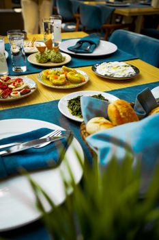 A beautifully set dining table with various appetizers and bread, creating an elegant dining experience.
