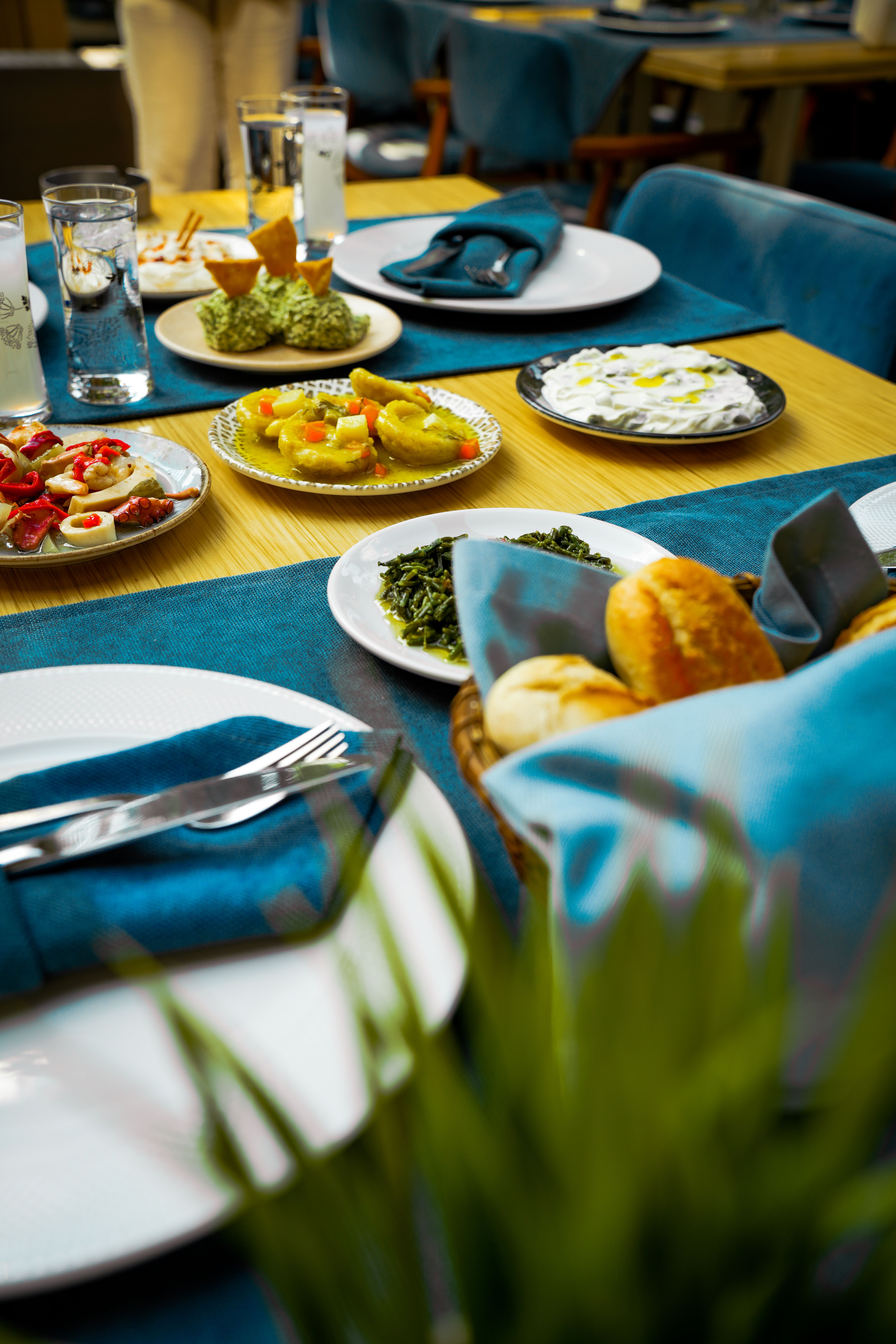 Ücretsiz Çeşitli mezeler ve ekmeklerle donatılmış, şık bir yemek deneyimi yaratan, özenle hazırlanmış bir yemek masası. Stok Fotoğraflar