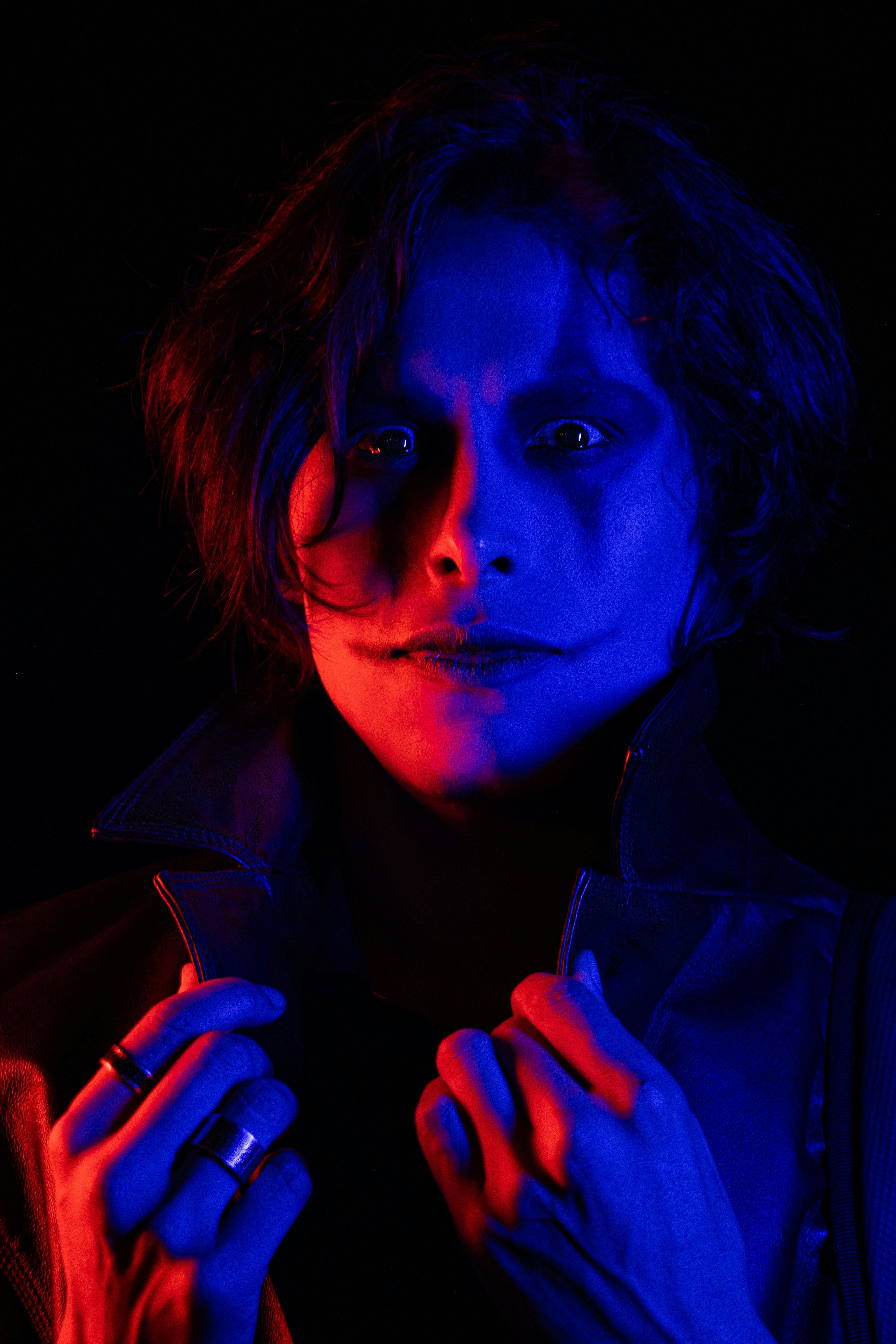 An artistic portrait of an adult with dramatic RGB lighting, evoking a cinematic and moody vibe.