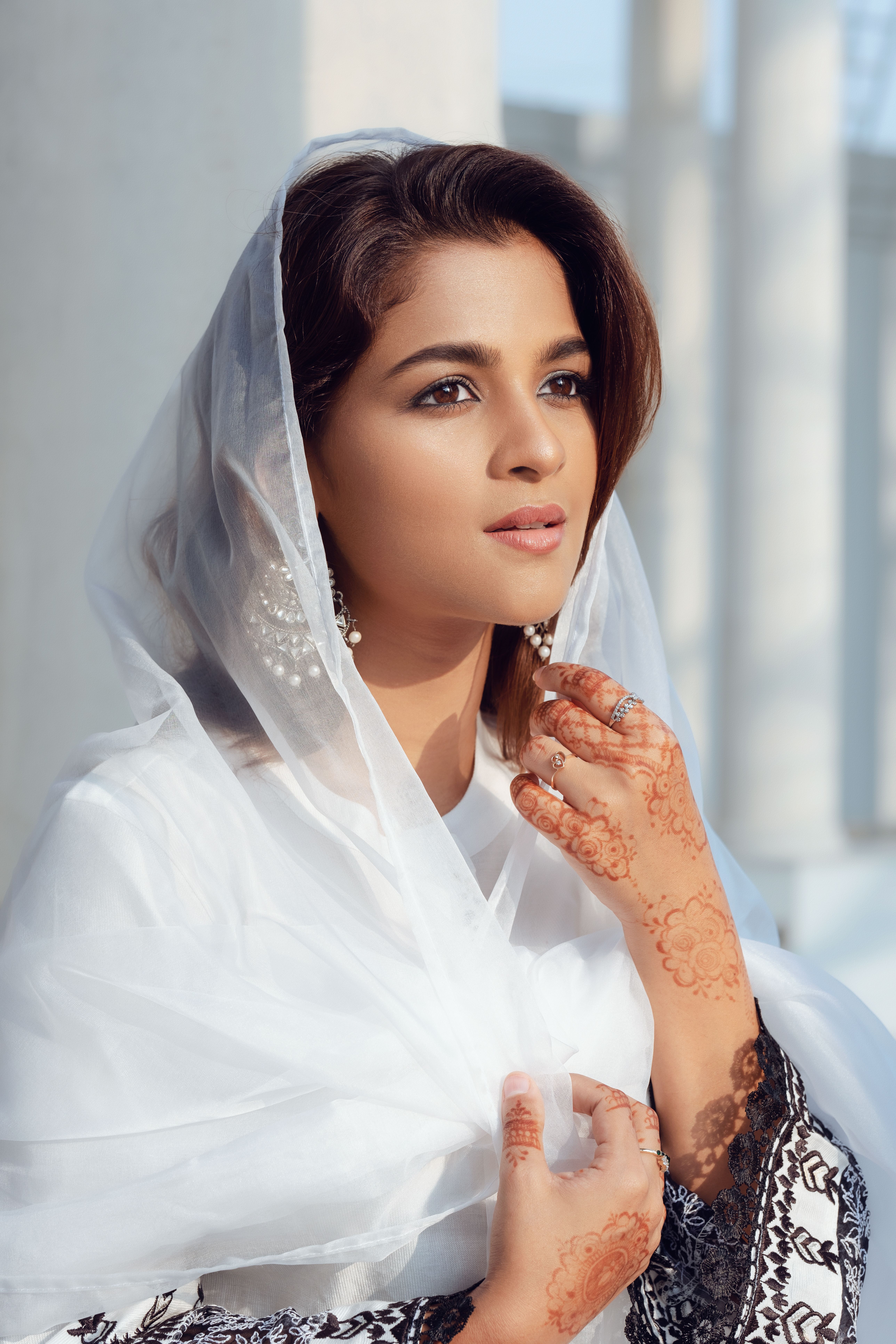 Portrait of a woman in Dhaka wearing traditional South Asian attire and henna designs.