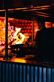 A vibrant scene of a street food vendor cooking in a night market, illuminated by neon lights.