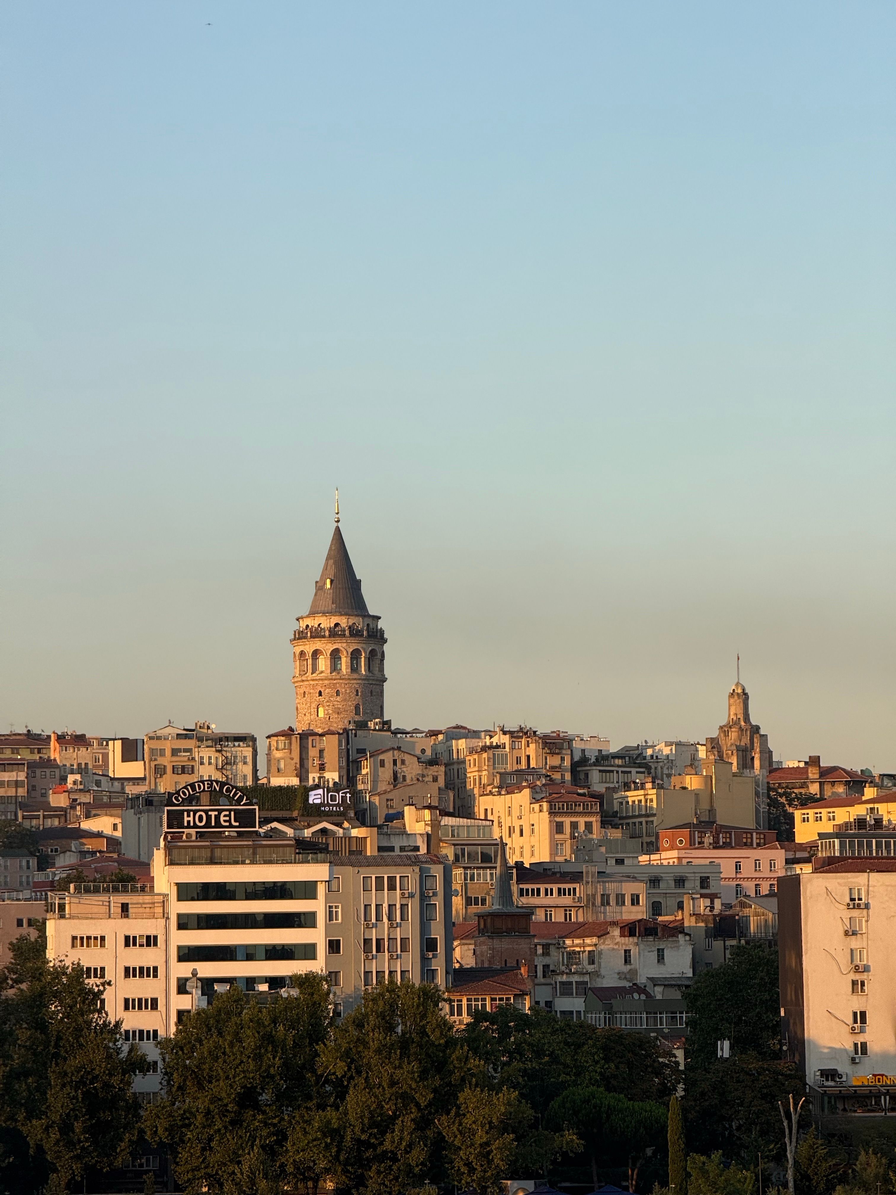 Captivating sunset view of the historic Galata Tower surrounded by Istanbul's urban landscape.