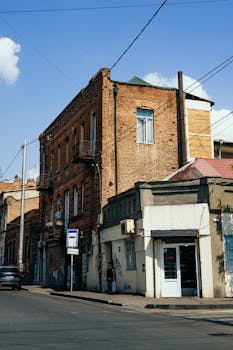 Street view of a classic brick building in Tbilisi, showcasing Georgian architecture and urban environment.