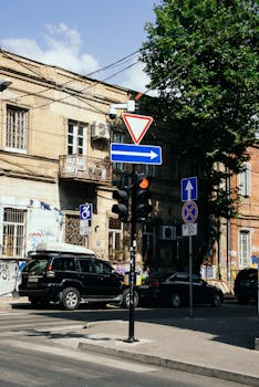 Street corner in Tbilisi, Georgia with traffic signs and old architecture.