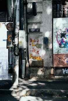 Creative street graffiti on an old wall with electrical poles in Tbilisi, Georgia.