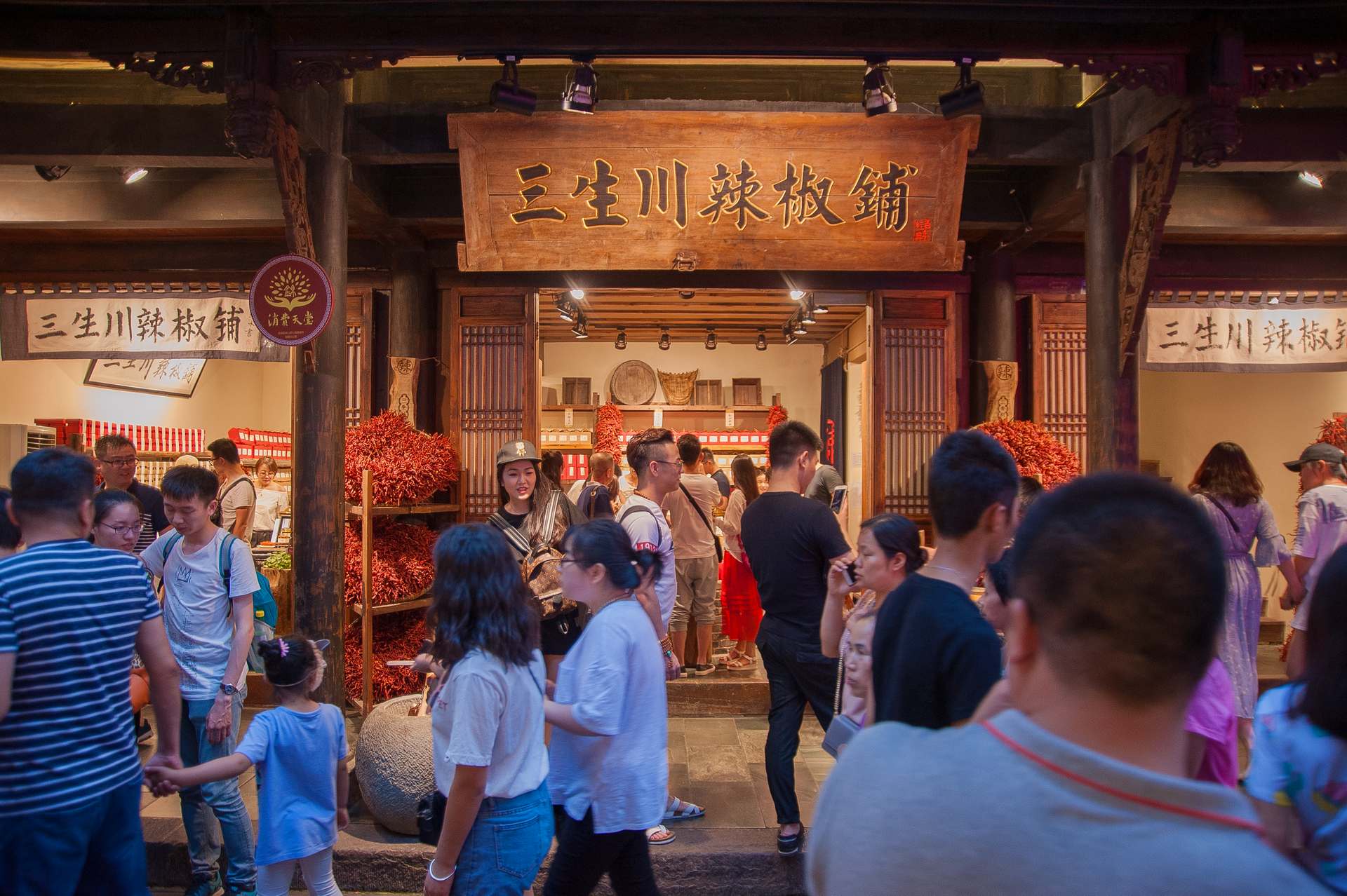 People exploring a vibrant market street with a traditional Chinese spice shop.