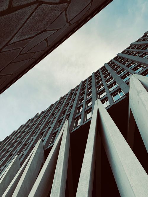 Free Low-angle view of a modern skyscraper in Amsterdam showcases its unique architectural design. Stock Photo