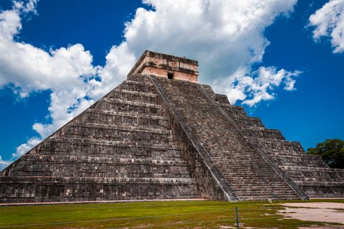 Free Impressive view of El Castillo pyramid against a vibrant blue sky at Chichén Itzá, Mexico. Stock Photo