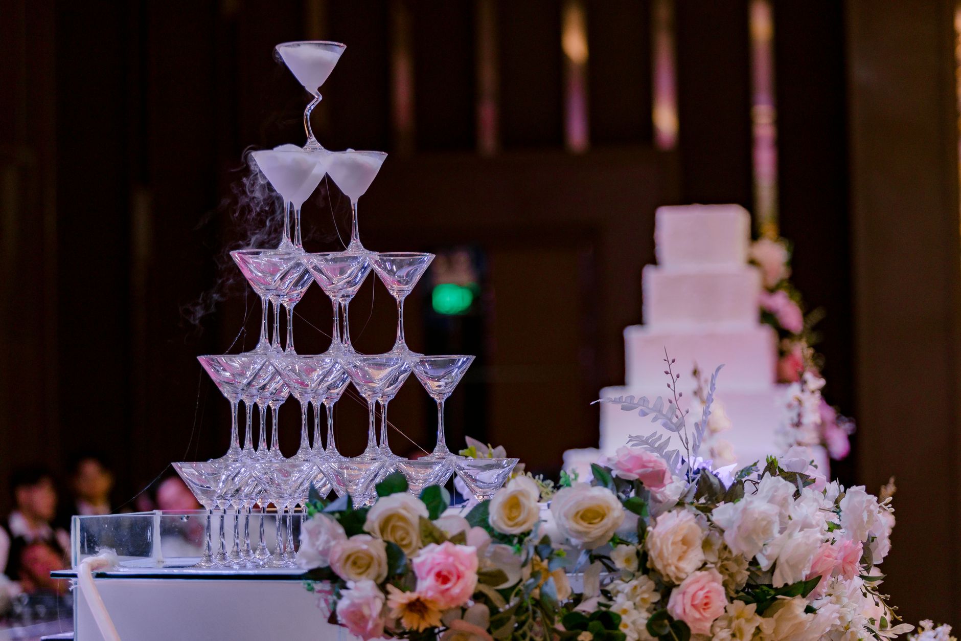 Elegant champagne tower with floral decor at a wedding reception. Perfect for celebratory and luxurious themes.