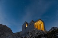 斯洛文尼亚山区的星夜映衬下，现代小屋显得格外明亮