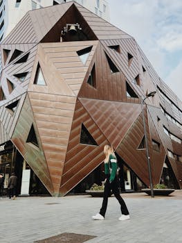 一名妇女走过一座具有引人注目的几何设计的现代建筑立面