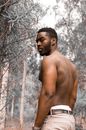 Topless Man in White Shorts Standing Near Bare Trees