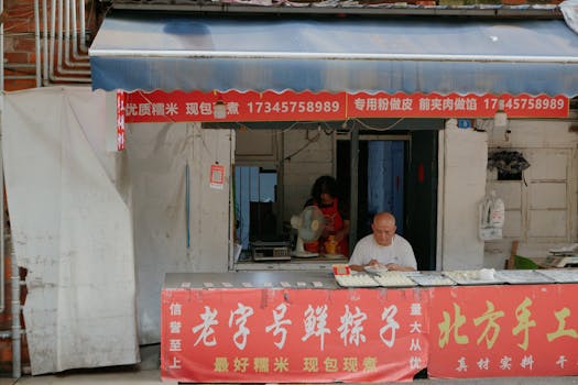 Authentic Asian street vendor preparing fresh dumplings at a small, local food stall.