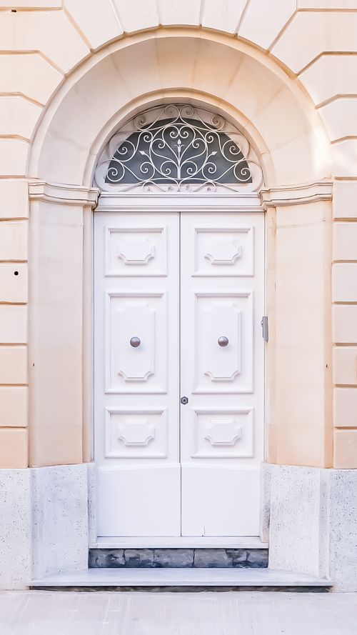 Free A timeless neoclassical white doorway with ornate arch and elegant symmetry, showcasing architectural beauty. Stock Photo
