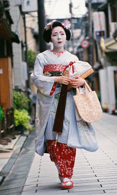 Geisha in kimono walking through Kyoto, showcasing Japanese culture.