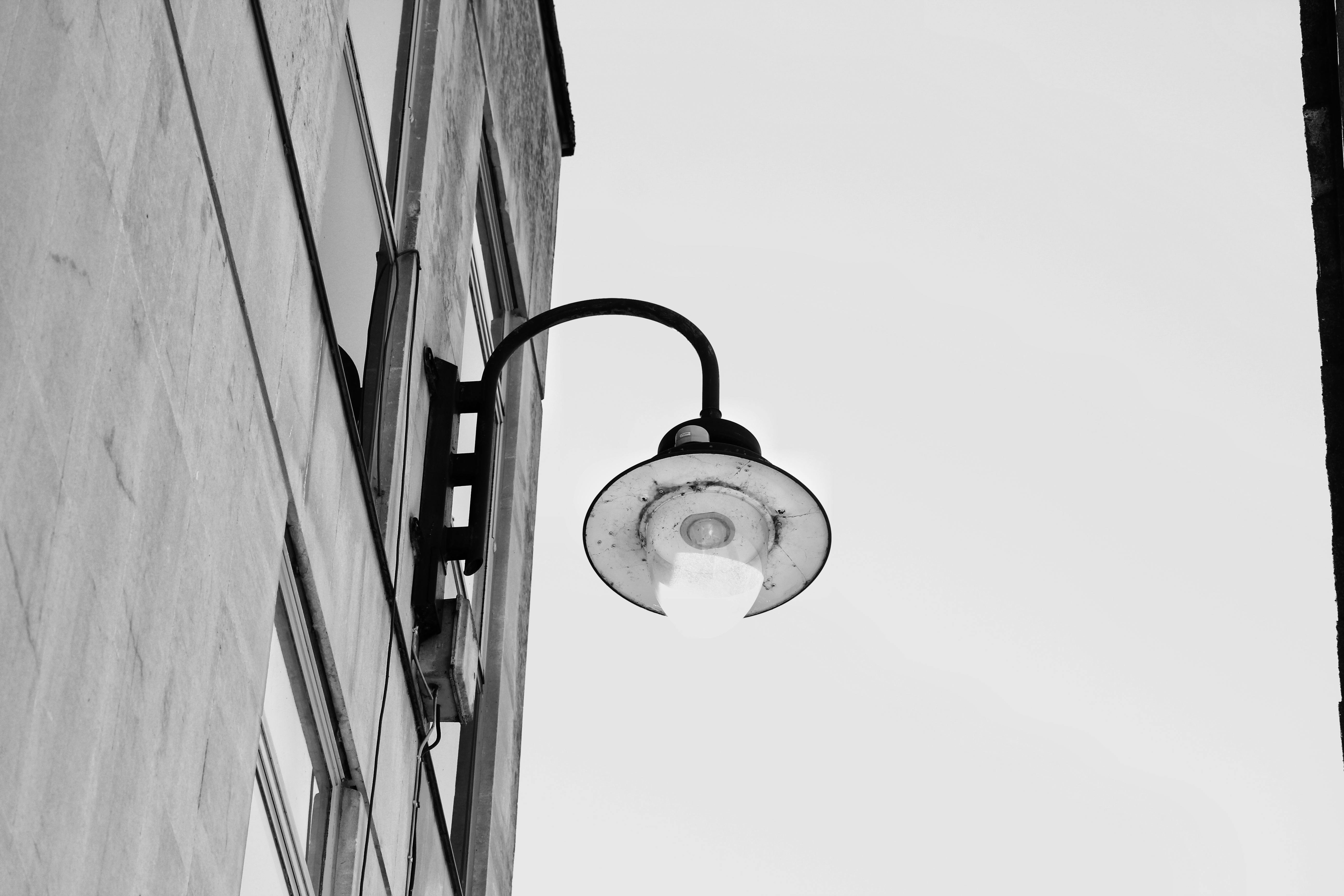 De franc Imatge monocroma d'un fanal de carrer vintage enganxat a la façana d'un edifici. Foto d'estoc