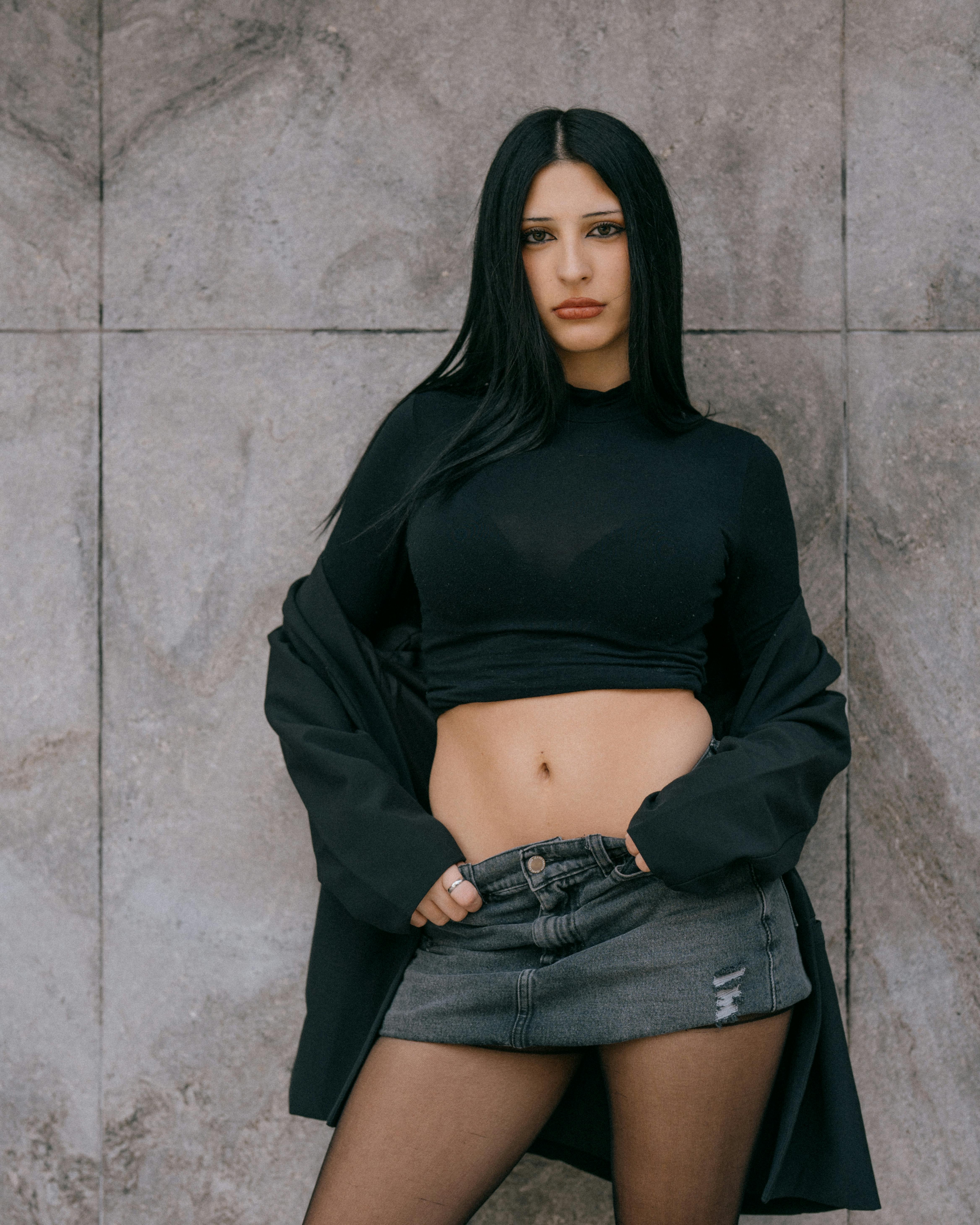 grátis Mulher elegante posando em frente a um muro urbano cinza em Buenos Aires, Argentina. Foto profissional