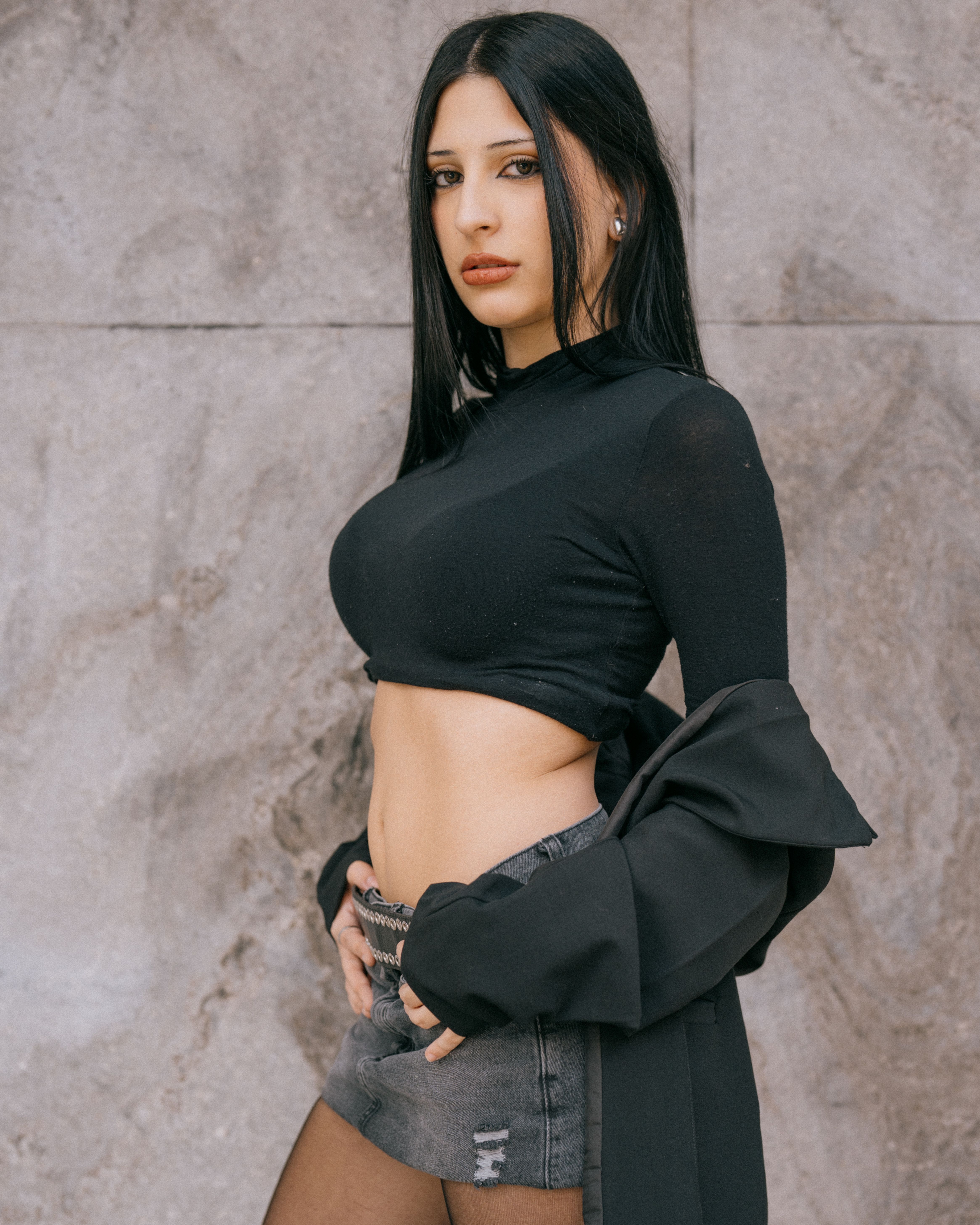 Confident woman posing in trendy black top and denim in Buenos Aires, Argentina.