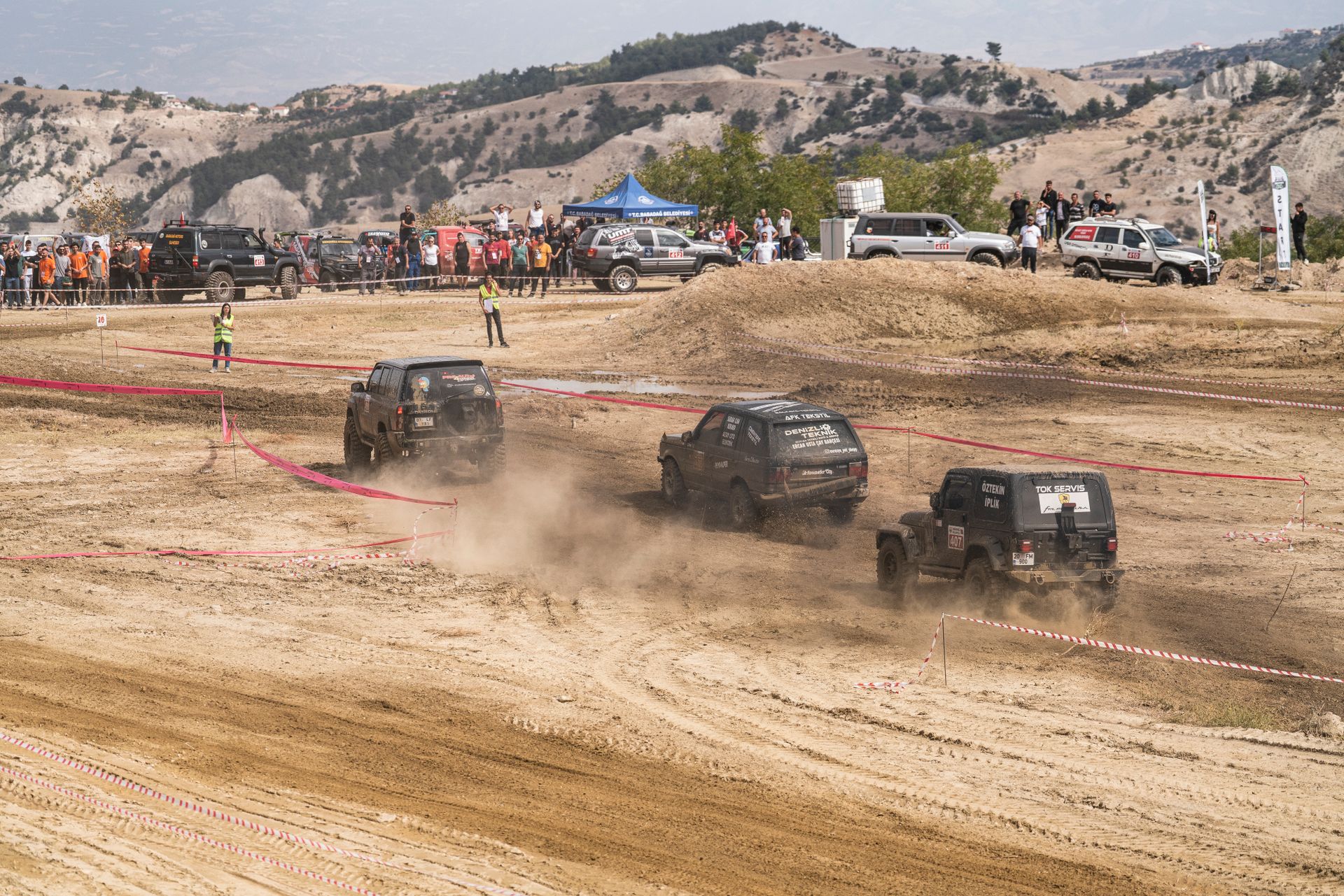 Exciting off-road race with rugged SUVs kicking up dust on a challenging dirt track.