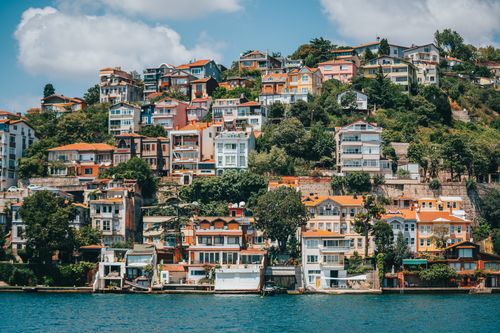 Free Colorful hillside houses overlooking a serene waterfront in a serene landscape. Stock Photo